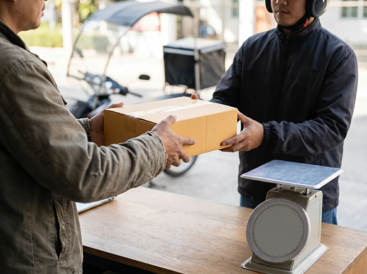 Customer handing an insured parcel containing a MacBook to a courier rider